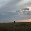 A view of the Semipalatinsk Test Site's ground zero monument in the Kazakh steppe under a cloudy sky at sunset.