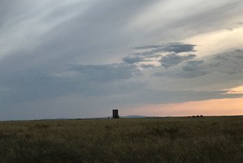 A view of the Semipalatinsk Test Site's ground zero monument in the Kazakh steppe under a cloudy sky at sunset.