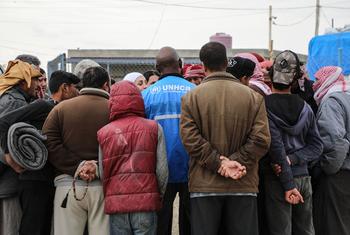 A UNHCR staff member provides information to a group of internally displaced people at Areesha camp, northeast Syria...