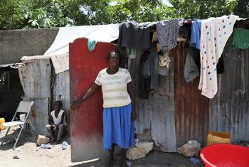 Mwanamke akiwa amesimama mbele ya nyumba yake kwenye eneo la watu waliohamishwa huko Port-au-Prince, Haiti.