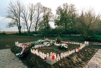 Candles and wreaths mark a mass grave site at Ovcara, Croatia, where approximately 200 civilians were massacred in 1994.