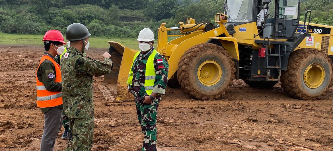 Un instructeur des Forces d'autodéfense terrestres japonaises donne des conseils à des soldats indonésiens sur l'utilisation d'un bulldozer pour niveler le sol lors d'un cours de formation sur l'utilisation d'équipement lourd dans les missions de maintie…