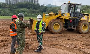 A Japanese Ground Self Defense Forces instructor provides tips to Indonesian soldiers on using a bulldozer to level the ground on a training course on operating heavy equipment at UN peacekeeping missions.