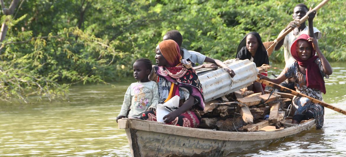 Uma família que perdeu sua casa para as inundações transporta o que resta de sua casa por canoa escavada no Extremo Norte de Camarões.