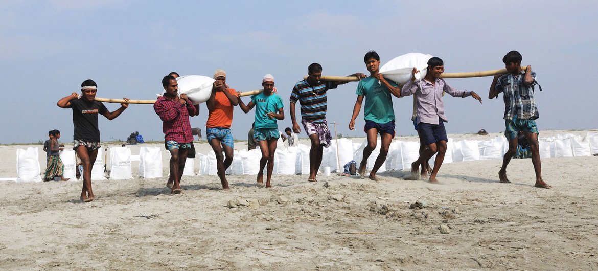印度的河边，人们往河岸上放置沙袋，以防止风暴潮和洪水。