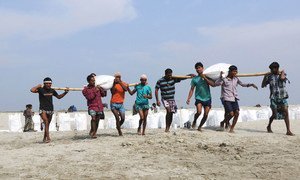 Sand bags are being placed on the banks of a river in India to provide protection against storm surges and floods.
