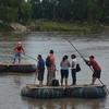 Un grupo de personas atraviesa en balsa el río Suchiate, cruzando la frontera entre Guatemala y México.