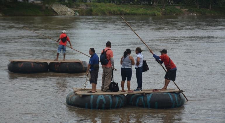 Un grupo de personas atraviesa en balsa el río Suchiate, cruzando la frontera entre Guatemala y México.