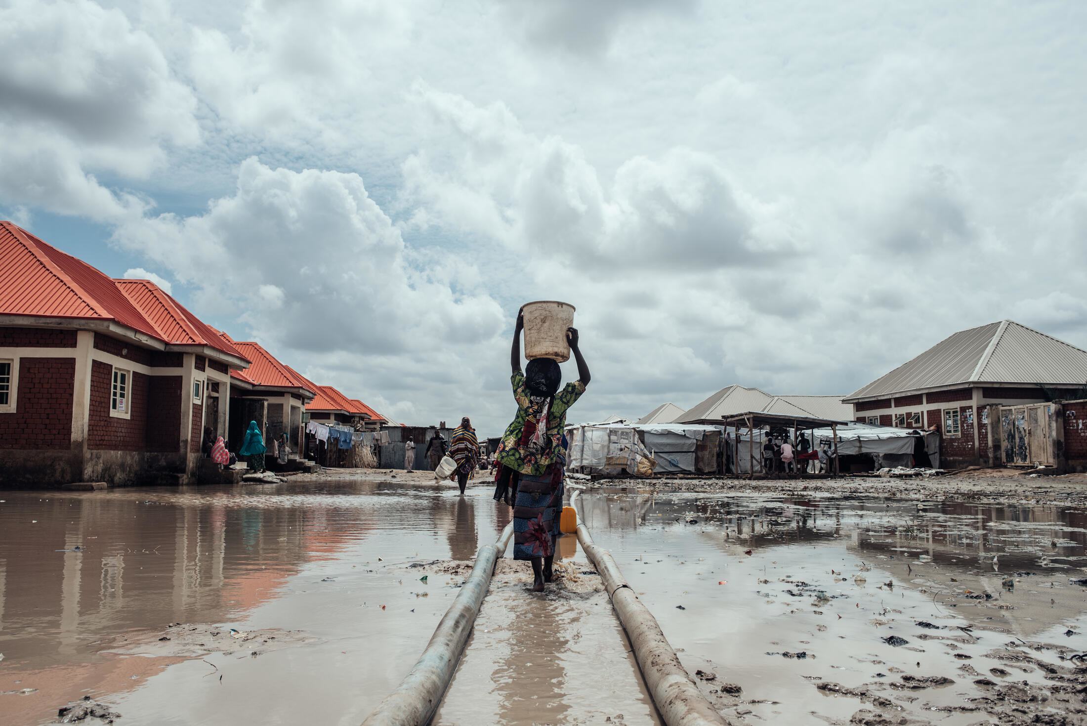 Des millions de personnes sont toujours déplacées au Nigéria en raison des conflits, des effets du changement climatique et des catastrophes naturelles. Sur cette photo d'archive, une fille transporte de l'eau jusqu'à son abri dans un camp de personnes d…
