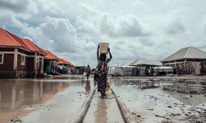 Millions remain displaced across Nigeria due to conflict, climate change impacts and natural disasters. In this file photo, a girl carries water to her shelter at an IDP camp in the country's northeast. (file)