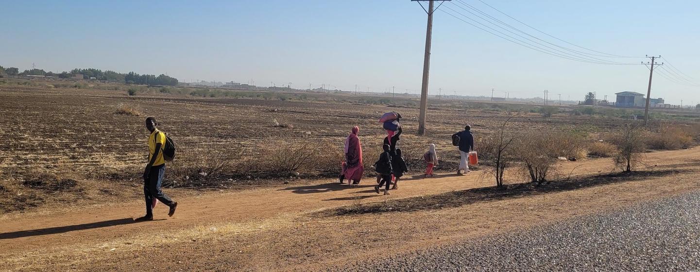 Des enfants et des familles fuient à pied après l'éruption de combats à Wad Madani, dans l'Etat d'Al Jazira (photo d'archives)..