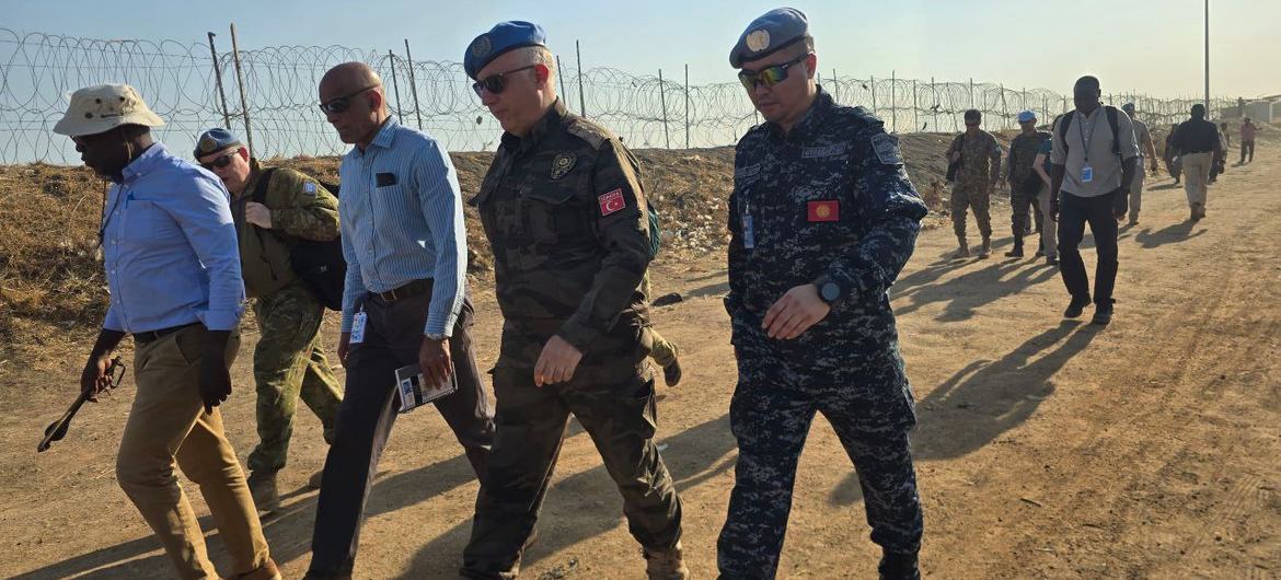 Миротворцы и сотрудники ООН идут по грунтовой тропе на базе UNMISS) в Южном Судане.