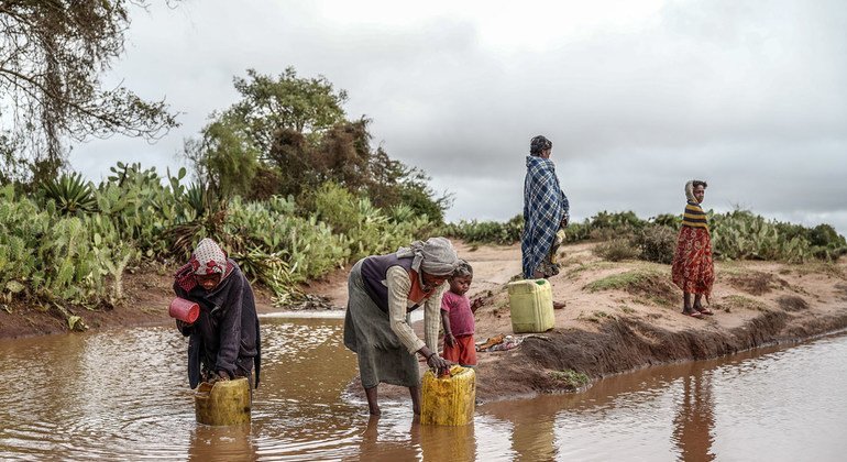 मेडागास्कर के दक्षिण में अंबोवोमबे से 13 किमी दूर अंबोहिमलाज़ा जाने वाली सड़क से बारिश का पानी इकट्ठा करता एक परिवार