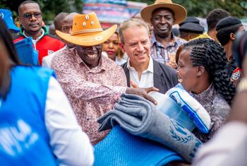 联合国驻肯尼亚协调员与该国副总统一道向洪水灾民分发救济物品。