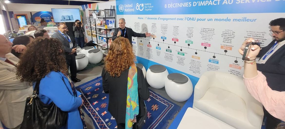 مدير مركز الأمم المتحدة للإعلام بالرباط، فتحي الدبابي (يسار)، يقدم الخط الزمني لثمانية عقود من محطات الأمم المتحدة وسبعة عقود من مشاركات المغرب في إطار الأمم المتحدة خلال افتتاح جناح الأمم المتحدة في معرض الرباط الدولي للكتاب.