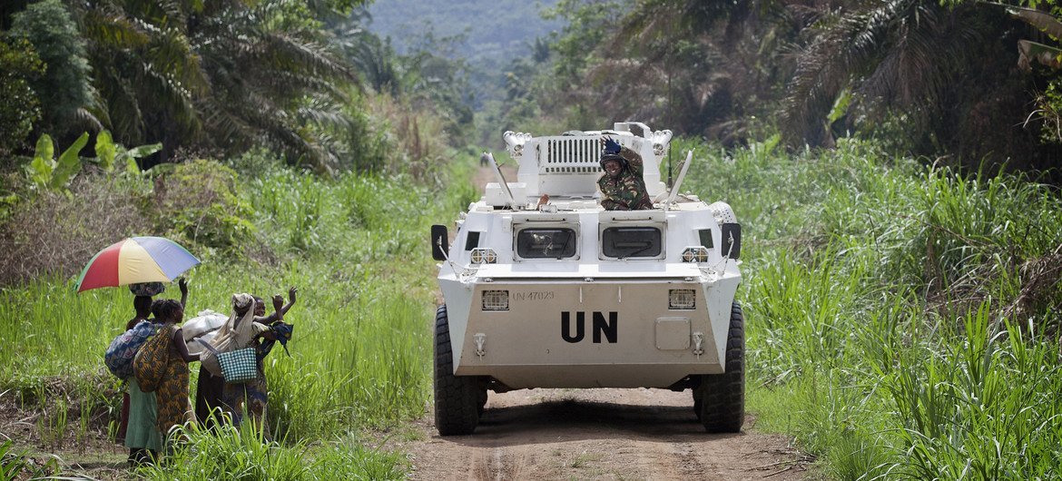 Des habitants de la région de Beni en RDC saluent le passage de soldats de la paix dans un véhicule blindé de transport de troupes de la MONUSCO. 