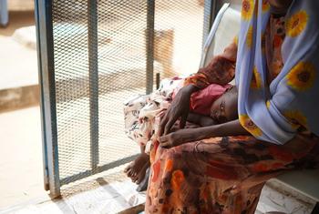 أم تنتظر مع طفلها في مركز صحي مدعوم من اليونيسف في الفاشر، دارفور، السودان.