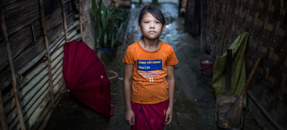 ایک بچی میانمار میں بے گھر افراد کے کیمپ میں اپنی جھونپڑی کے باہر کھڑی ہے۔