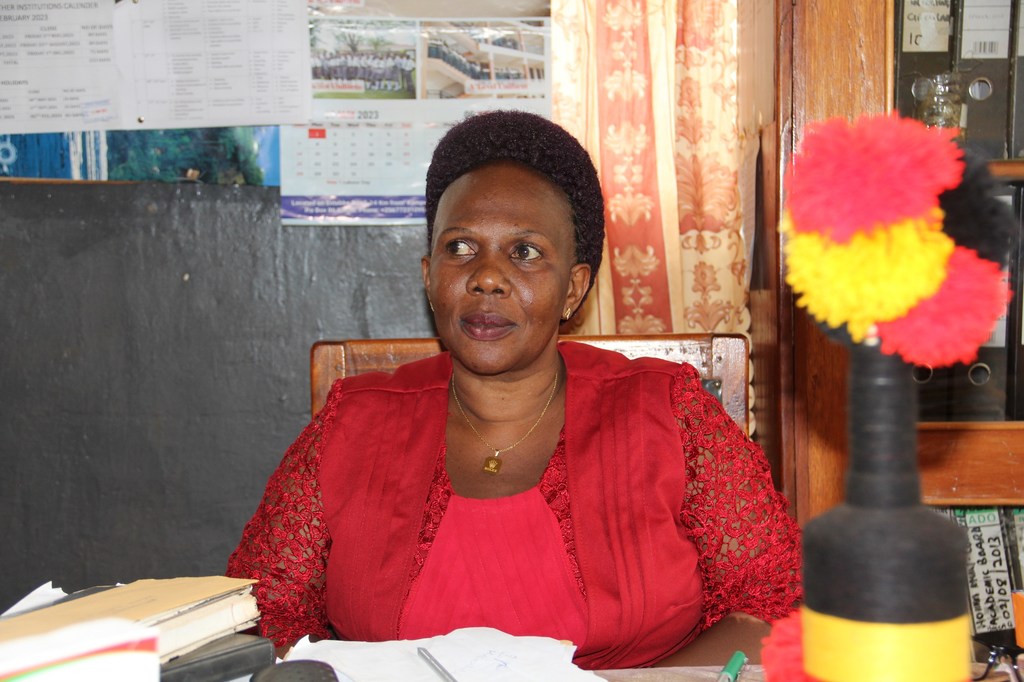 Herriet Karing, mwalimu katika shule ya serikali huko Hoima, Uganda, ameketi kwenye dawati lake.