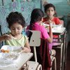 Estas niñas salvadoreñas eran beneficiarias de los almuerzos escolares. Ahora esas raciones de alimentos se preparan  para que los niños se los lleven a sus casas. 