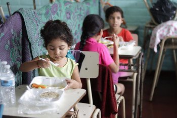 Estas niñas salvadoreñas eran beneficiarias de los almuerzos escolares. Ahora esas raciones de alimentos se preparan  para que los niños se los lleven a sus casas. 