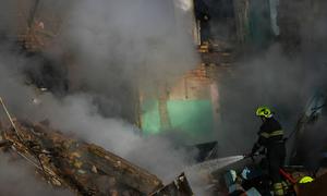 A firefighter works through thick smoke at the ruins of a residential building in Kyiv destroyed by a missile strike on 28 August.