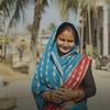 Bibha, mnufaika wa mradi wa IFAD, kutoka Nepal, akiwa amevaa sari ya bluu, amesimama katika mazingira ya kijijini.