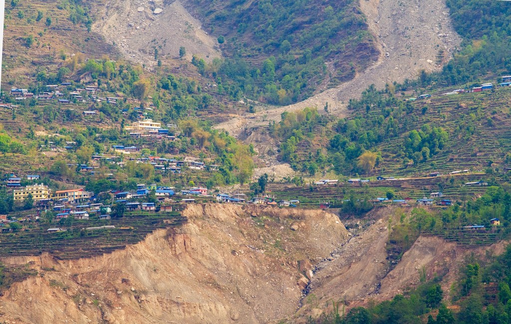 नेपाल के लापिलांग जिले में एक क्षतिग्रस्त गांव 2020 में हुए भूस्खलन के बाद के हालात को दर्शाता है, जहां सीढ़ीदार खेतों के बड़े हिस्से मिट्टी और वनस्पति से पूरी तरह से नष्ट हो गए हैं।