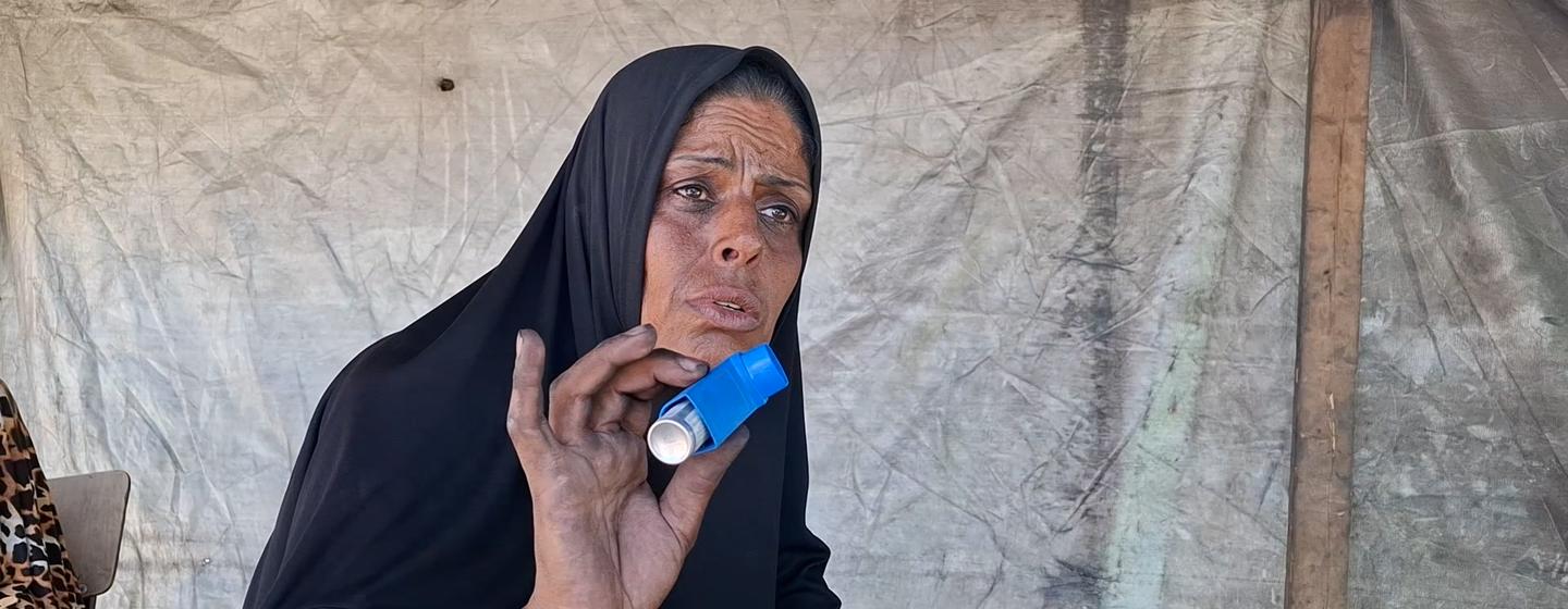 Um Mohammed Al-Masri, displaced from Beit Hanoun to the south of the Strip, working at a clay oven to bake bread and cook food for displaced people to support her family.