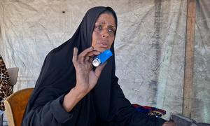 Um Mohammed Al-Masri, displaced from Beit Hanoun to the south of the Strip, working at a clay oven to bake bread and cook food for displaced people to support her family.