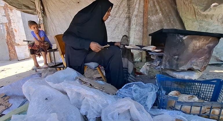 उम मुहम्मद अल-मसरी भट्ठी में भोजन पकाते हुए.