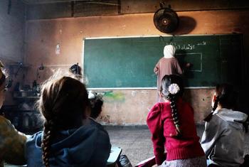 Profesores interactuando con alumnos en la escuela primaria mixta Deir al-Balah, gestionada por la UNRWA.