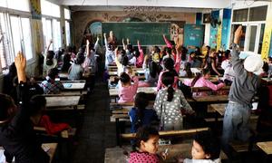 A teacher engaging with students in a classroom in Deir al-Balah Co-educational Primary School, run by UNRWA.