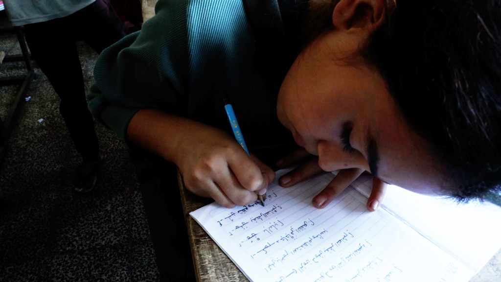 الطالبة شام العبد أثناء كتابة دروسها في فصل دراسي في مدرسة دير البلح المشتركة في قطاع غزة التي تديرها وكالة الأونروا. الطالبة شام العبد أثناء كتابة دروسها في فصل دراسي في مدرسة دير البلح المشتركة في قطاع غزة التي تديرها وكالة الأونروا.