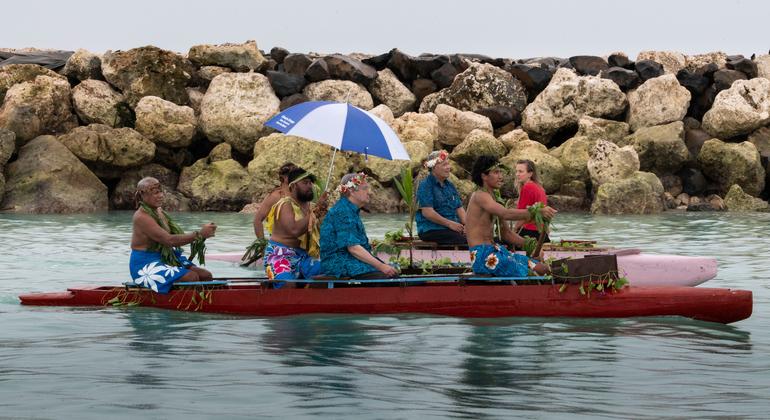 秘书长古特雷斯（中）乘坐独木舟，与图瓦卢总理索波阿加（右三）一起仔细观察填海造地情况。 