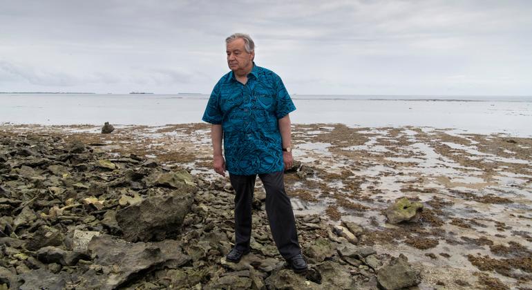 秘书长古特雷斯站在图瓦卢的一条堤道上。涨潮时，海水会从岛的一侧通过堤道流向另一侧。 