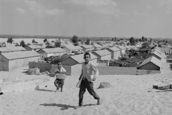 Palestine refugee children on their way to school in UNRWA's Khan Younis camp, built on the stand dunes of the crowded Gaza Strip in 1963.