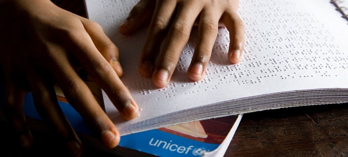 भारत को कोलकाता में, एक 13 वर्षीय लड़का, ब्रेल लिपि पढ़ते हुए.