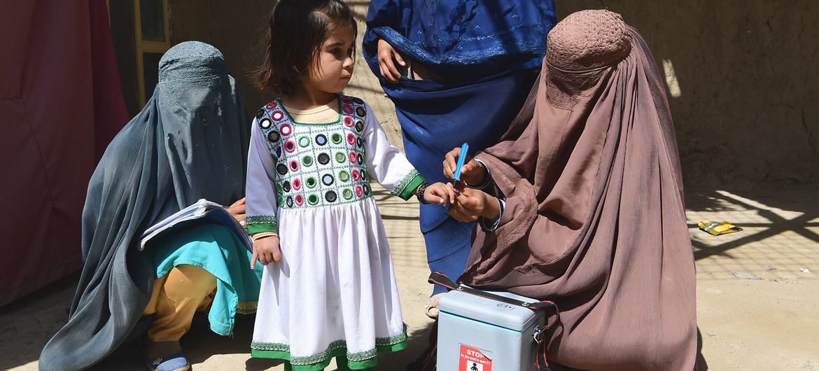 在阿富汗坎大哈进行的脊髓灰质炎防治运动中，一名儿童正在接种相关疫苗。