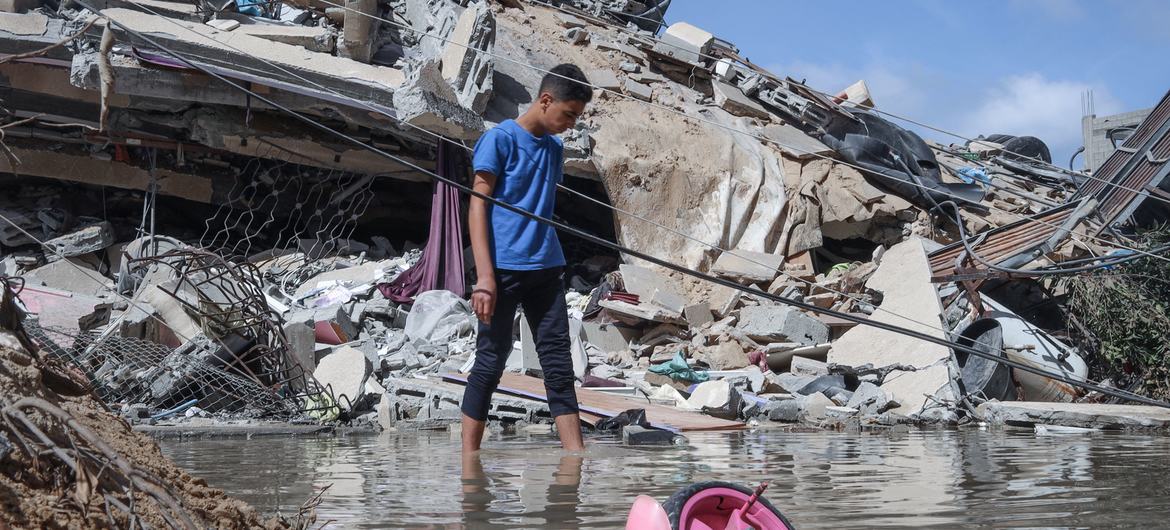 एक फ़लस्तीन लड़का गाजा शहर में अपने घर का निरीक्षण करता है जिसे इसराइली युद्धक विमानों ने निशाना बनाया था। (मई 2021)