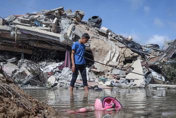 एक फ़लस्तीन लड़का गाजा शहर में अपने घर का निरीक्षण करता है जिसे इसराइली युद्धक विमानों ने निशाना बनाया था। (मई 2021)