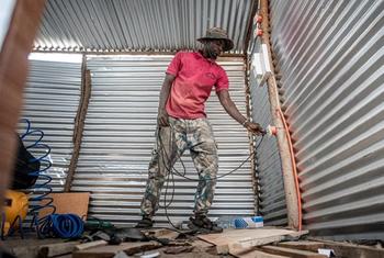 Seremala Djaraf akitumia plagi ya umeme kwa kazi zake.