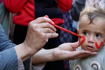 رسم على خد طفلة من غزة خلال فعالية ترفيهية في رفح مدعومة من الأونروا.