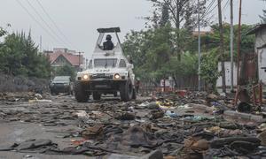 UN peacekeepers patrol Goma in the eastern DR Congo after the city is overrun by rebel forces. In the foreground, military uniforms and equipment have been abandoned on the road.