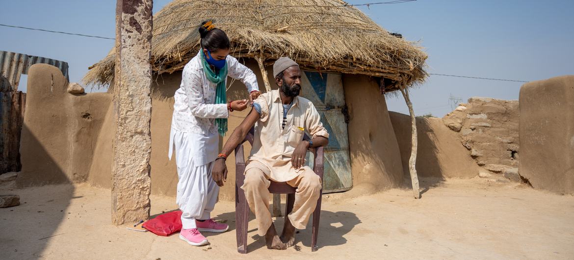 भारत के राजस्थान में डोर-टू-डोर वैक्सीन अभियान के दौरान एक व्यक्ति कोविड-19 वैक्सीन की अपनी दूसरी खुराक प्राप्त करते हुए. (फाइल)