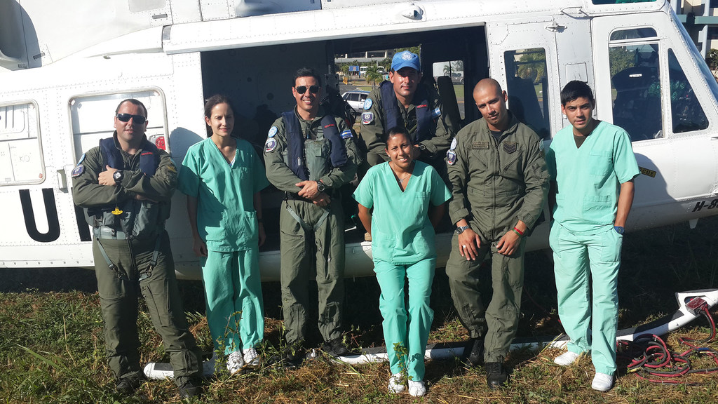 El comodoro Javier Chiappai, cascos azules de la ONU y personal sanitario posan frente a un helicóptero en la República Dominicana.
