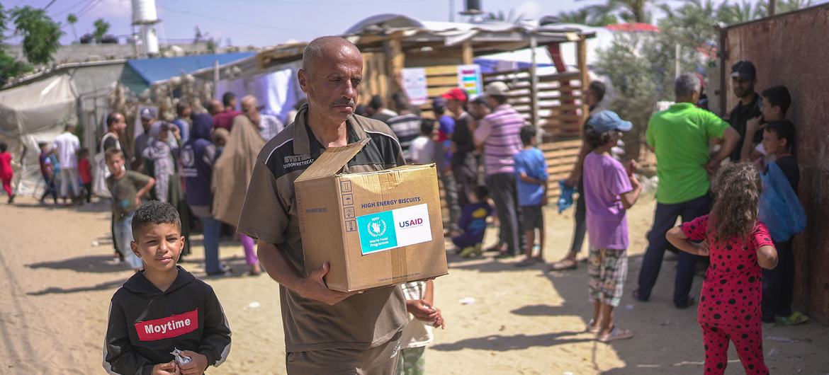 A man carries a parcel of high energy biscuits that just entered through the humanitarian maritime corridor.