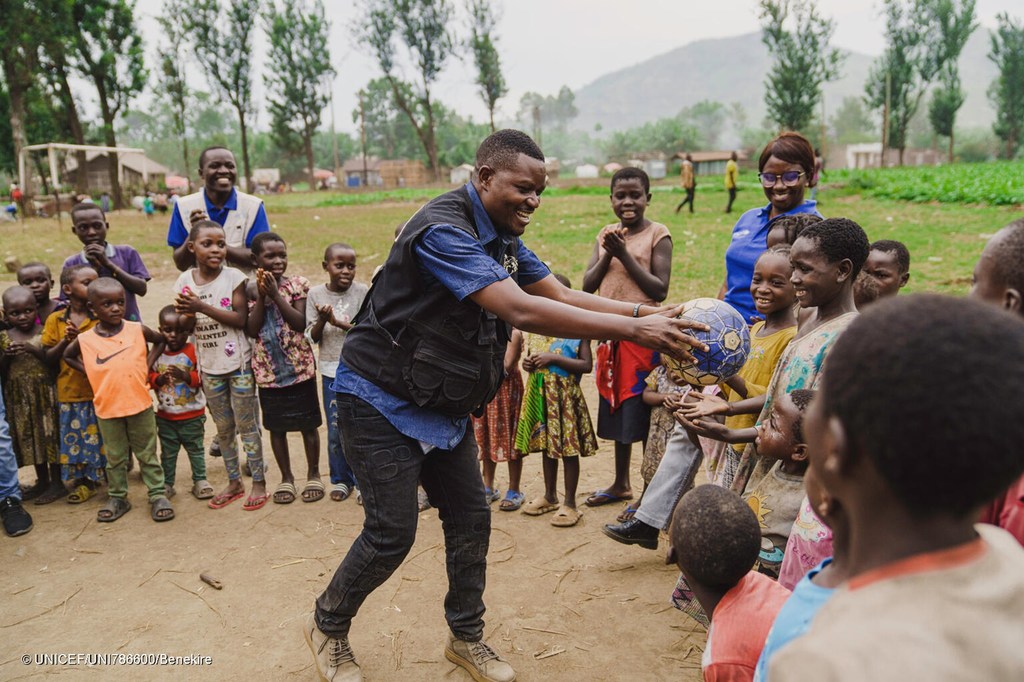 Bienfait Kizuri Mwanuka, mfanyakazi wa kijamii anayesaidiwa na UNICEF, anacheza na watoto katika eneo salama linalosaidiwa na UNICEF huko Bweremana, eneo la afya la Kirotche, jimbo la Kivu Kaskazini, DR Congo, tarehe 26 Machi 2025.