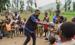 Un trabajador social, apoyado por UNICEF, juega con niños en un espacio seguro apoyado por UNICEF en Bweremana, en la provincia de Kivu Norte, RD del Congo, el 26 de marzo de 2025.