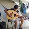 Un garçon joue de la musique à l'intérieur d'une tente à Gaza.